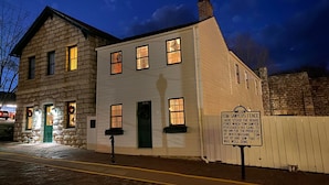 A historic building with a stone facade and multiple windows, featuring a sign about Tom Sawyer's fence.