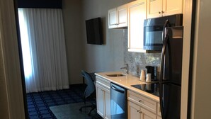 A compact kitchen with a refrigerator, microwave, and sink.