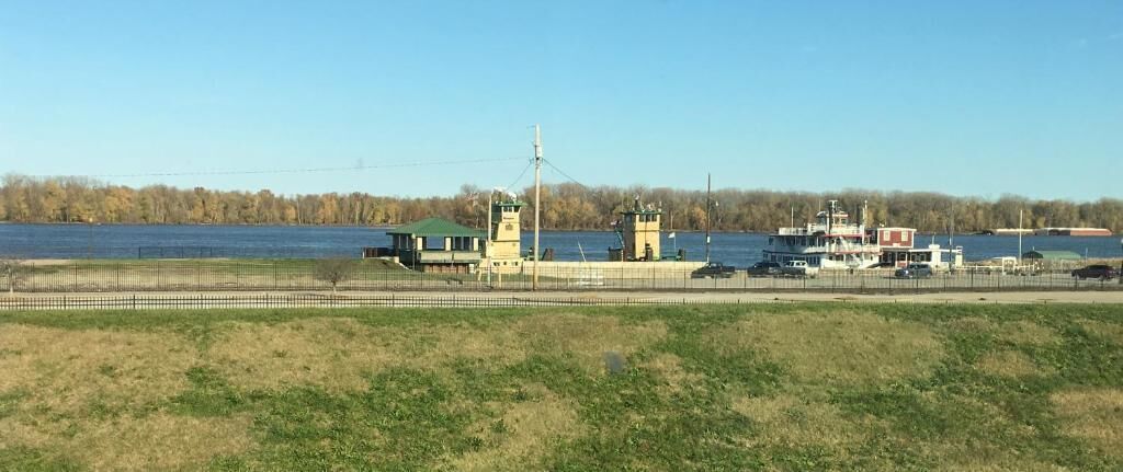 Una propiedad frente al agua con muelle, una construcción pequeña y un bote.