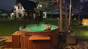 A hot tub in a backyard with a house in the background.