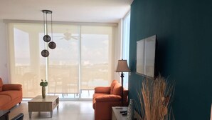 Un soggiorno moderno con un divano, un tavolino da caffè e un televisore su un mobile.