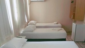 A hotel room with two beds, a wardrobe, and an air conditioning unit. - Goias Hotel (Goiania)