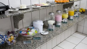 A buffet counter with various food items and beverages. - Presidente Hotel - Passos (Passos)