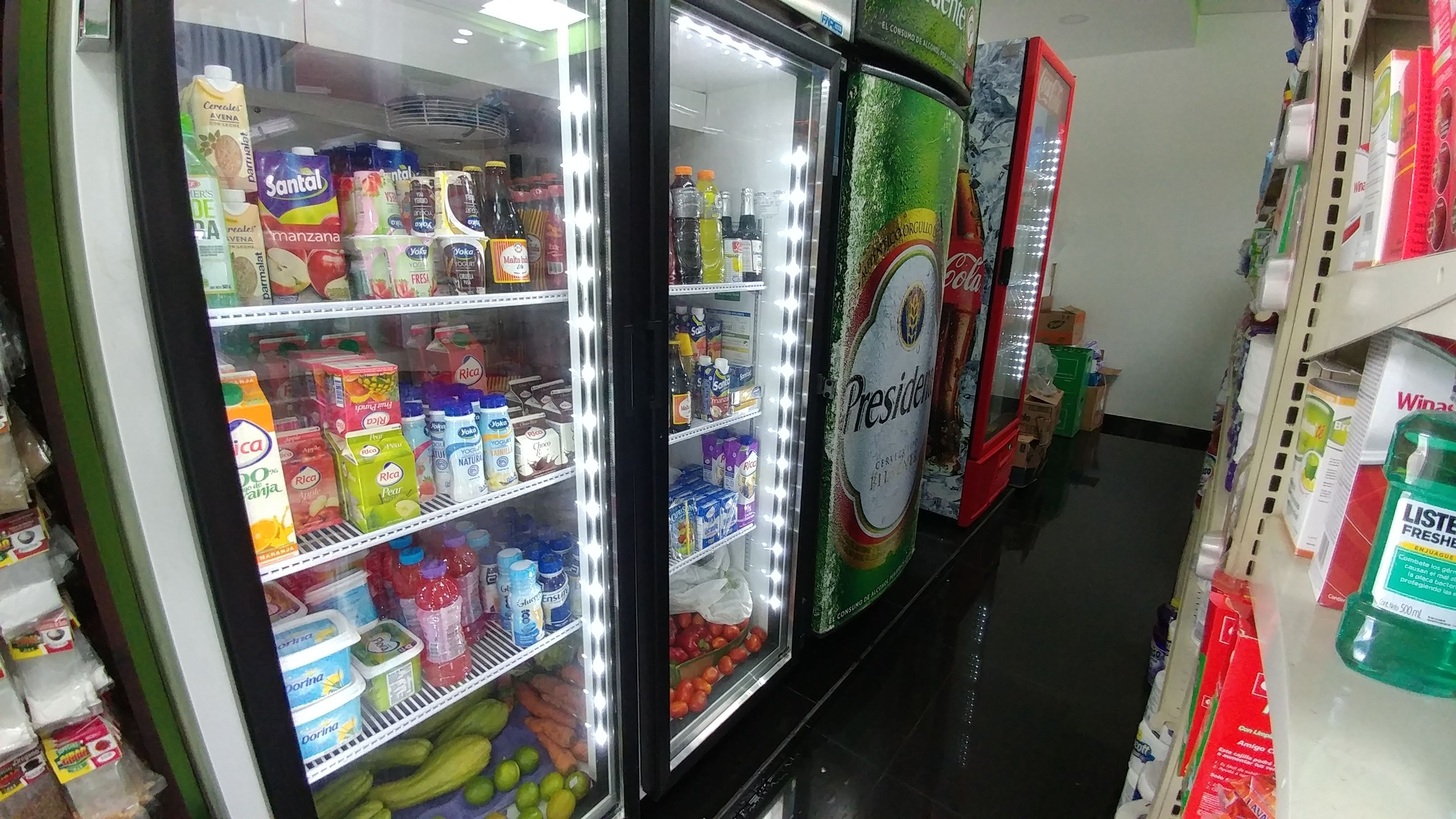 A refrigerated display case in a store with various dairy products and beverages.