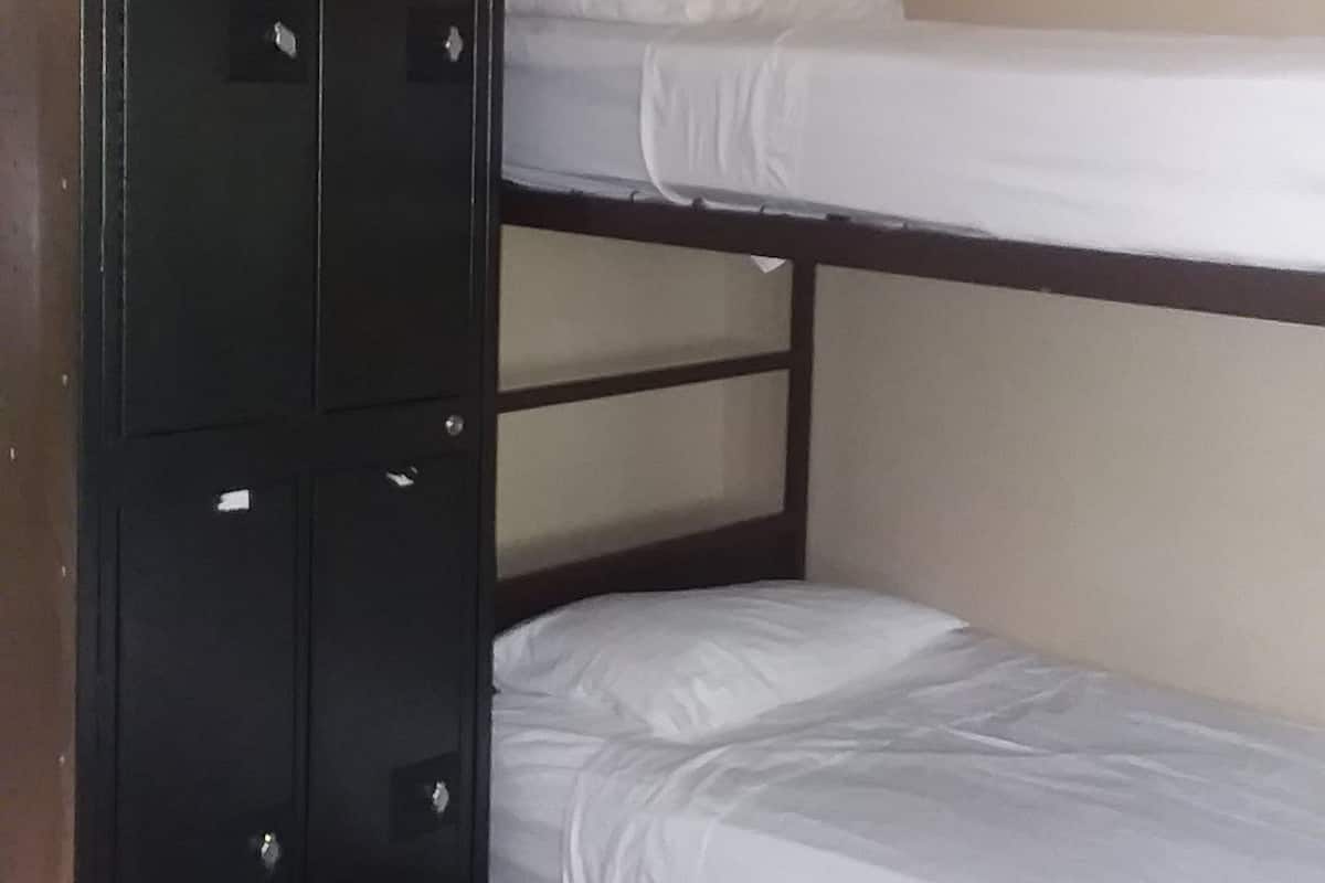 Una camera con letto a castello e un armadio in legno.