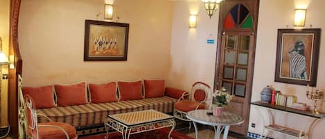 A traditional room with a sofa, chairs, a small table, and a decorative door.