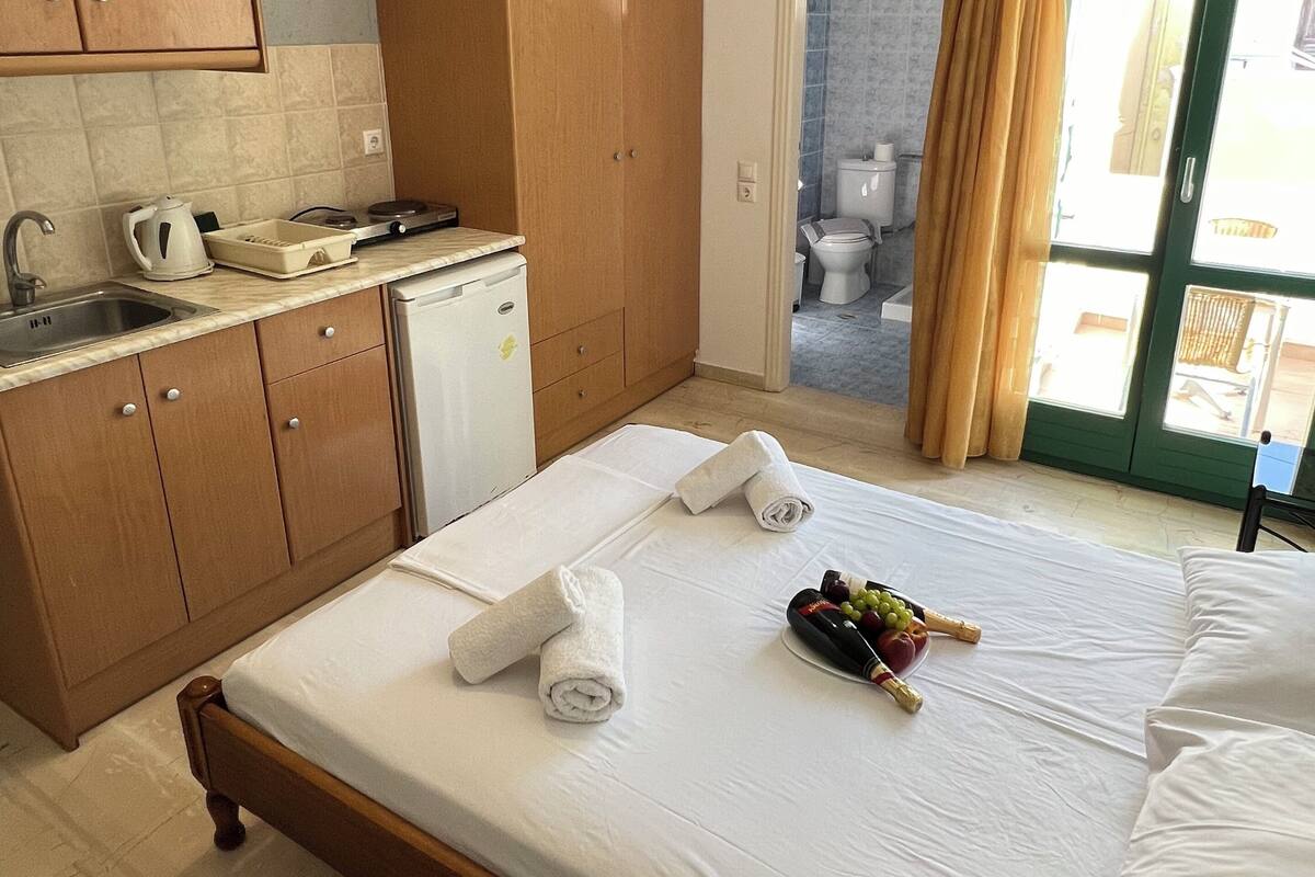 Une chambre d’hôtel avec un lit, une petite kitchenette, une salle de bain et une vue sur l’extérieur.