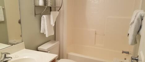 A bathroom with a sink, toilet, and bathtub.