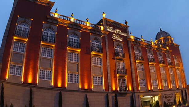 A large, historic building with multiple arched windows and a prominent dome on the right. - Villas Princess Hotel (Mexico City)