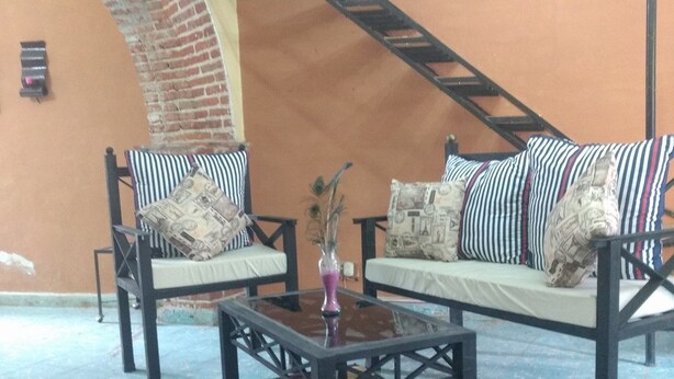 A living area with a sofa set, a coffee table, and a patterned rug. - Casa de Huespedes Independencia (San Miguel de Allende)