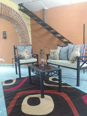 A living area with a sofa set, a coffee table, and a patterned rug. - Casa de Huespedes Independencia (San Miguel de Allende)