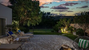 A patio with stone flooring, lounge chairs, and a table with a drink bucket. - Wonderful private villa for 8 guests with WIFI, private pool, A/C, TV, terrace and pets allowed (Rijeka)