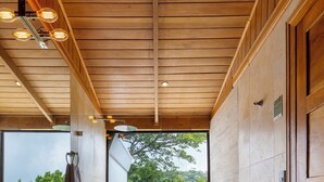 Une salle de bain moderne avec un plafond en bois, une grande fenêtre et un lavabo en pierre.