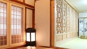 A traditional Japanese room with sliding doors, a lantern, and a tatami mat floor. - Gwiae Traditional House (Yeongcheon)