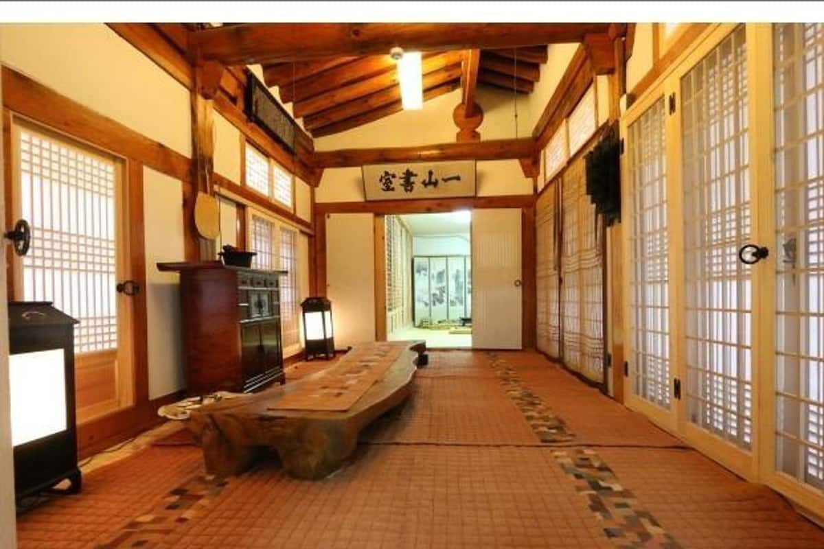 A traditional Japanese room with tatami flooring, sliding doors, and a low wooden table.