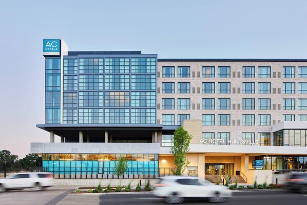 A hotel with a modern glass facade, a swimming pool, and a brick exterior. - AC Hotel Huntsville Downtown (Huntsville)