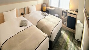 A hotel room with two beds, a small desk, a window with blinds, and a heater. - Urban Hotel Kyoto Gojo Premium (Kyoto)