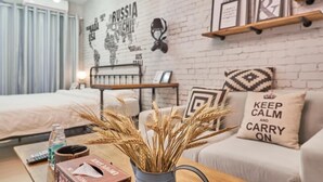 A modern hotel room with a white brick wall, a bed, a sofa, a coffee table with a vase of wheat, and a map of Russia on the wall. - Shenzhen Maiya Apartment (Shenzhen)