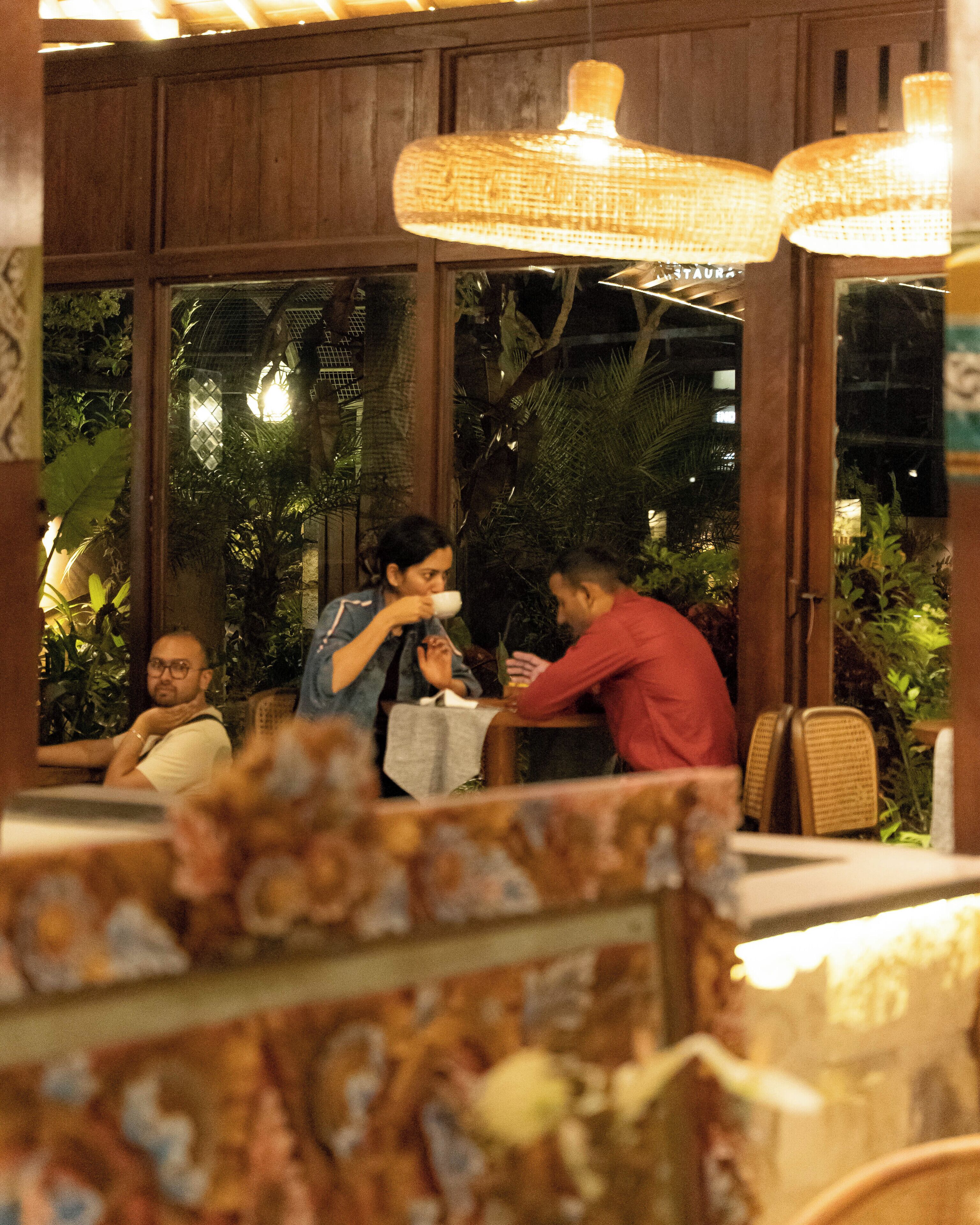 A restaurant with wooden paneling, large windows, and hanging lights.