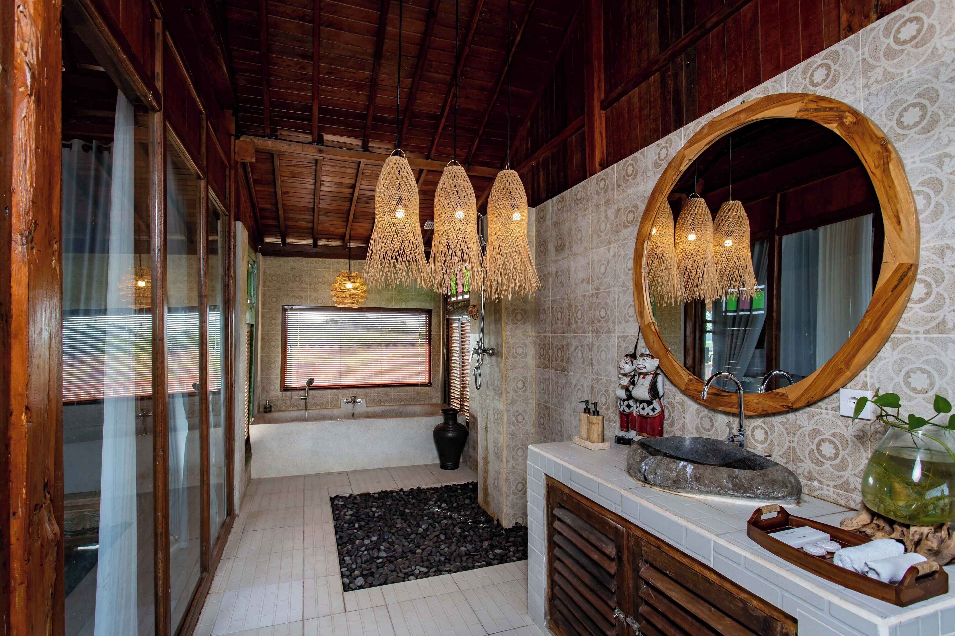 A bathroom with a bathtub, a sink with a large mirror, and a decorative vase.