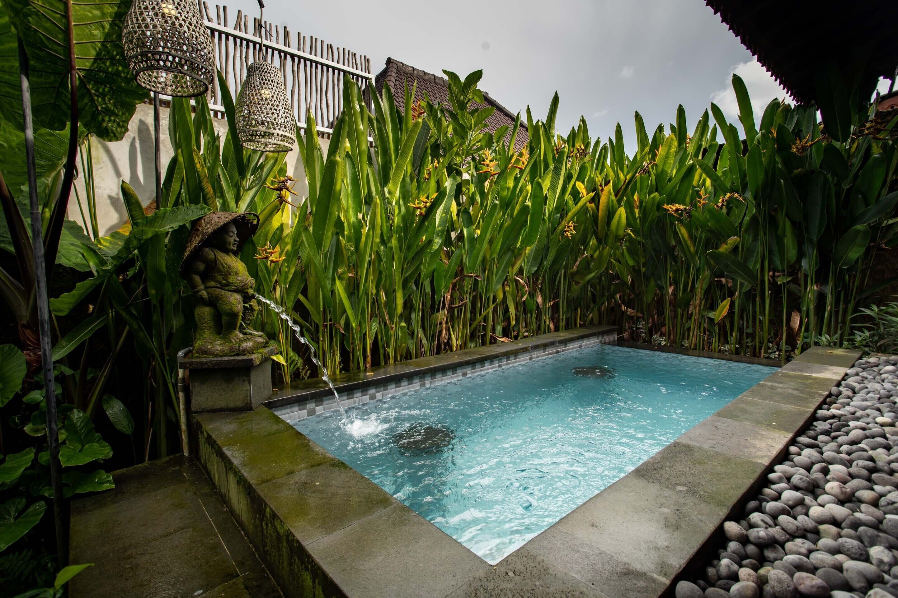 A rectangular pool with clear water, surrounded by a stone border and a bed of smooth pebbles.