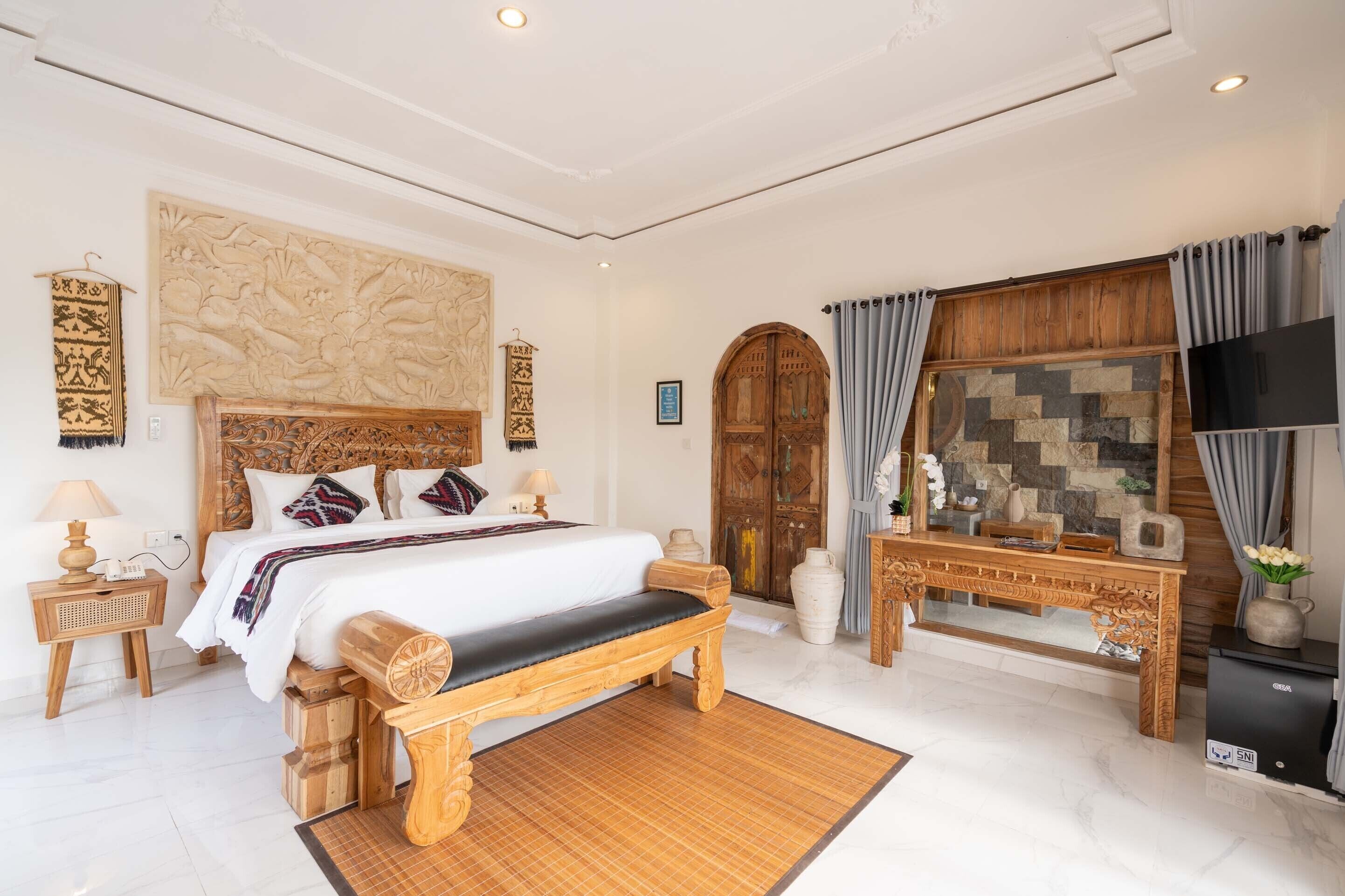 A spacious bedroom with a large bed, wooden headboard, and a decorative wall piece.
