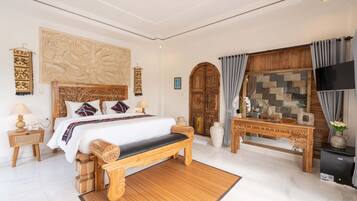 A spacious bedroom with a large bed, wooden headboard, and a decorative wall piece.