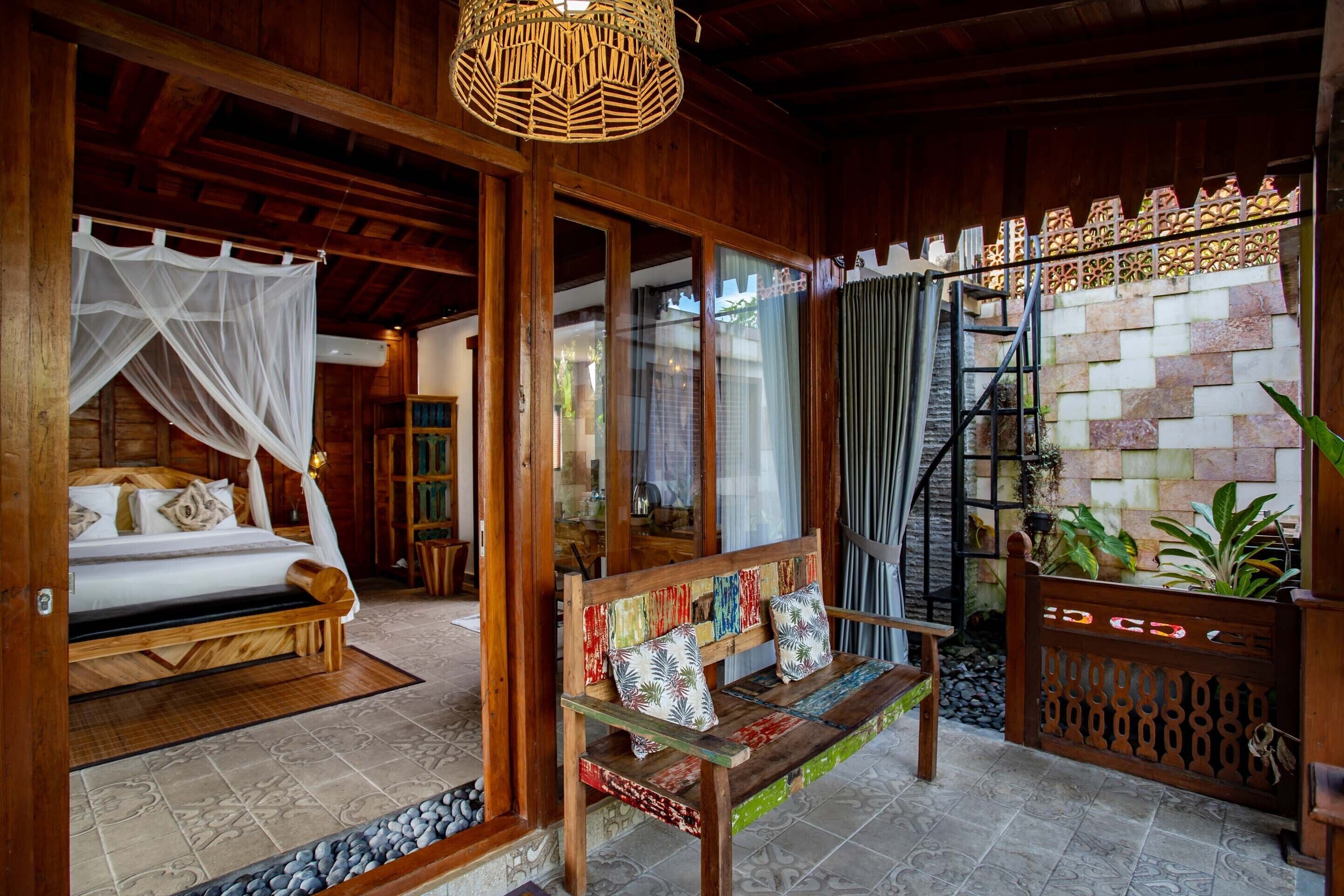 Una habitación de madera con una cama, un banco y una escalera.