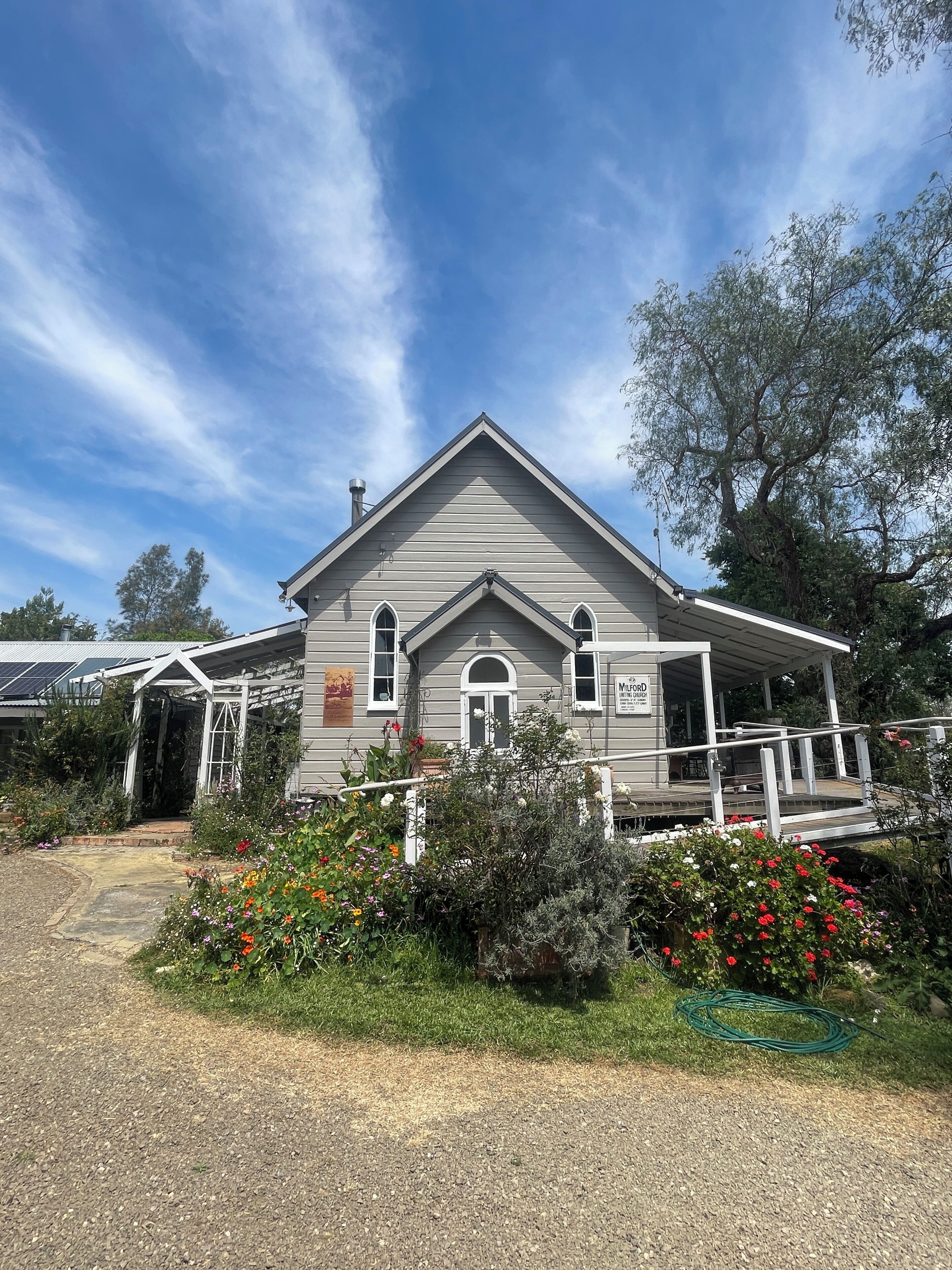 A two-story building with a gabled roof, a covered porch, and a sign that reads 'MLORD.'
