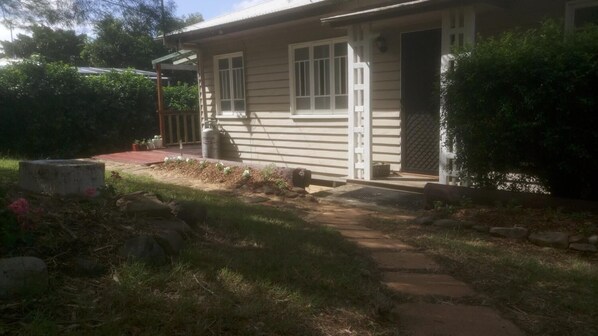 A single-story house with a front door, a small porch, and a pathway leading to the entrance. - Boonah Cottage (Boonah)