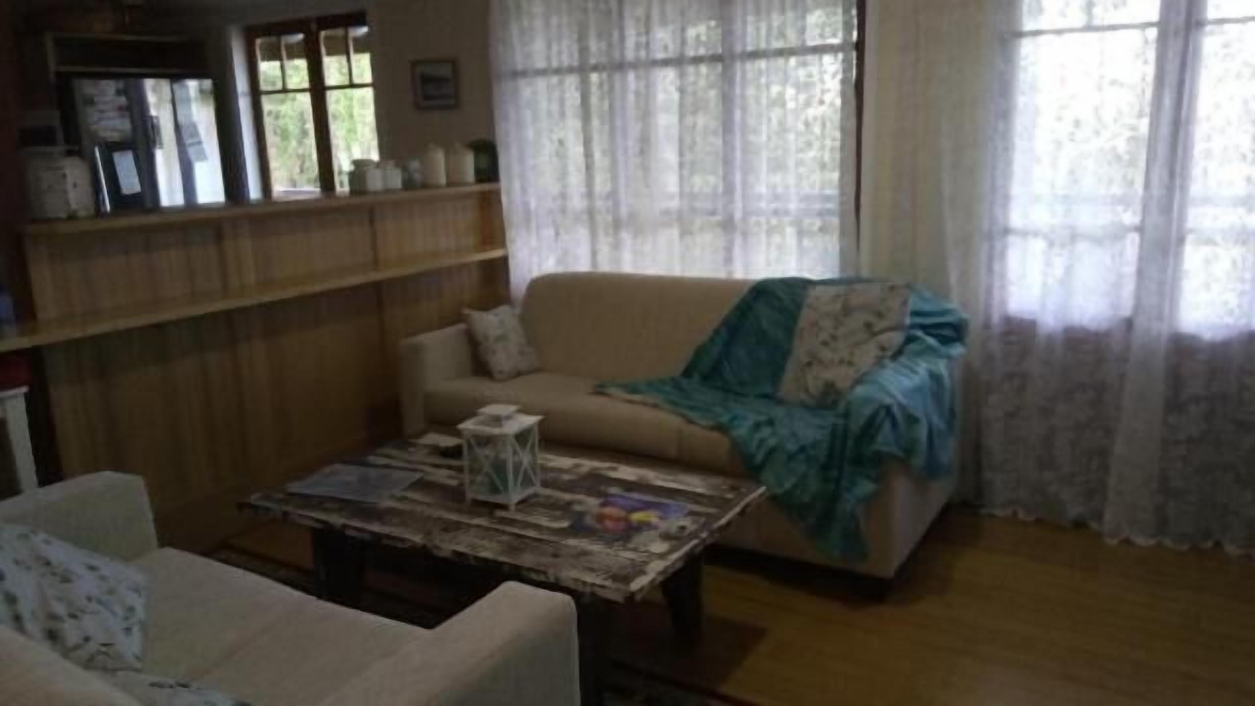 A living room with a sofa, a coffee table, and a bookshelf.