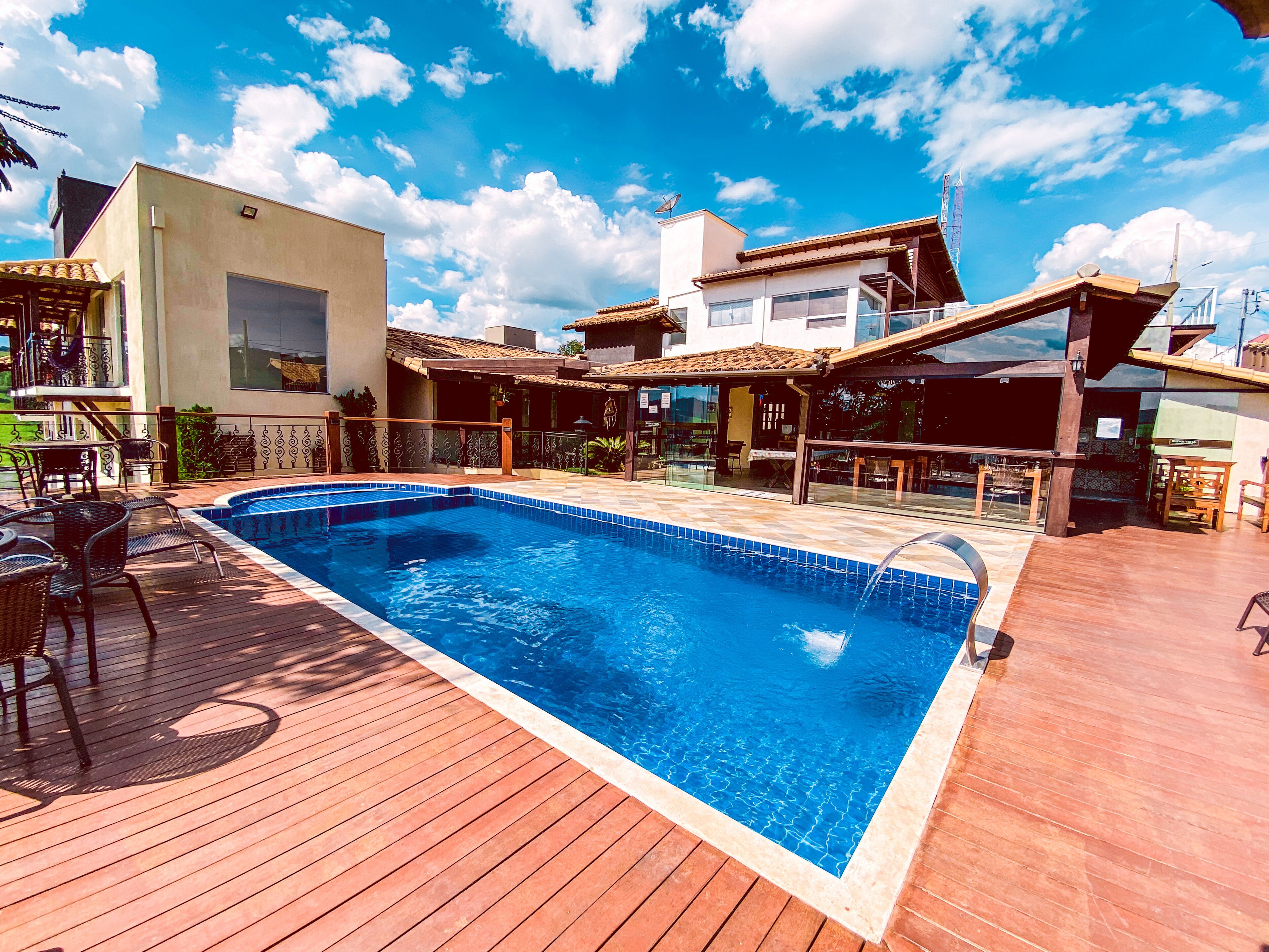 Una piscina al aire libre, sillones reclinables de piscina
