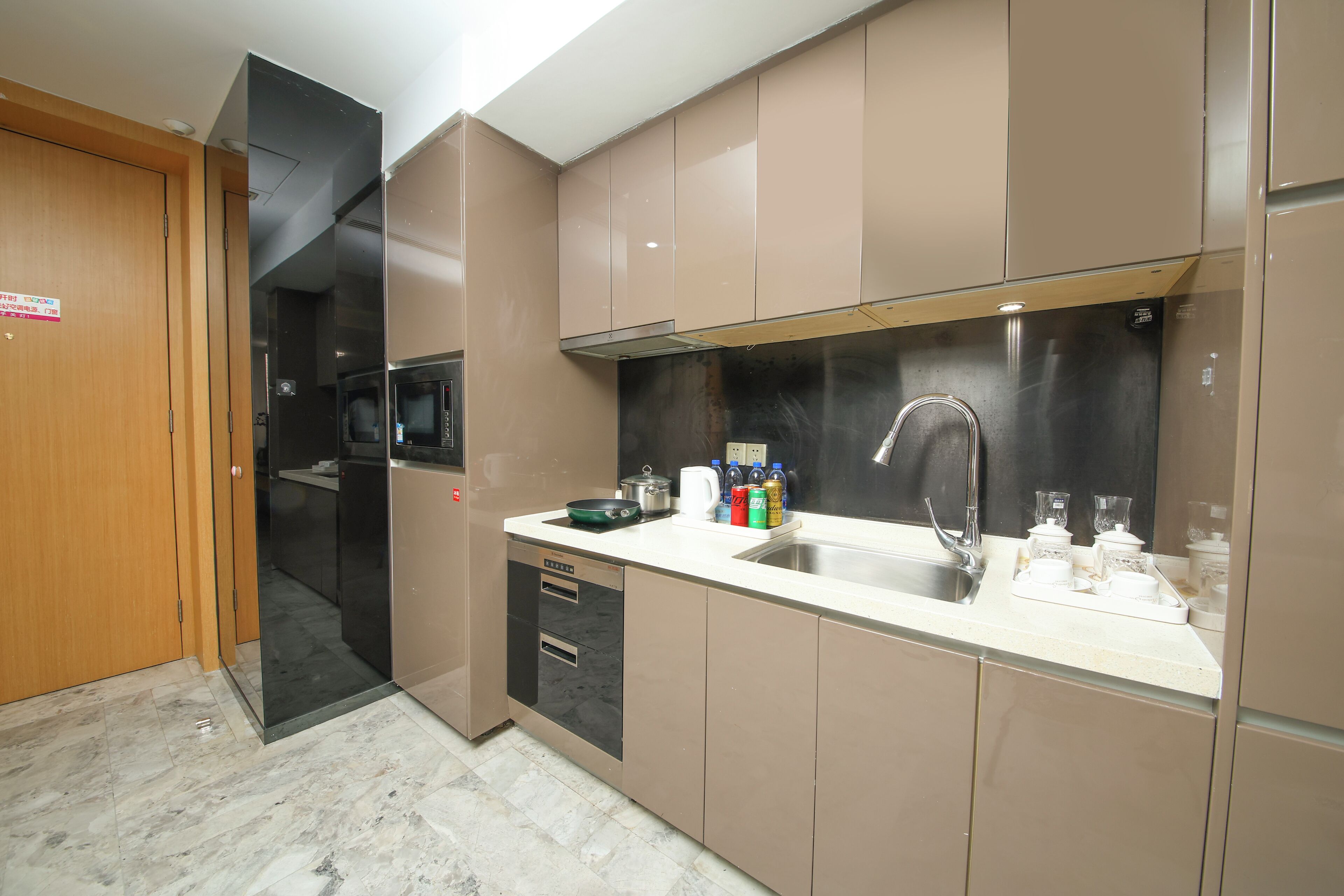 A modern kitchen with a stainless steel sink, a microwave, and a dishwasher.