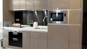 A modern kitchen with stainless steel appliances, a built-in oven, and a microwave. - Pengman International Apartment Hotel (Guangzhou)