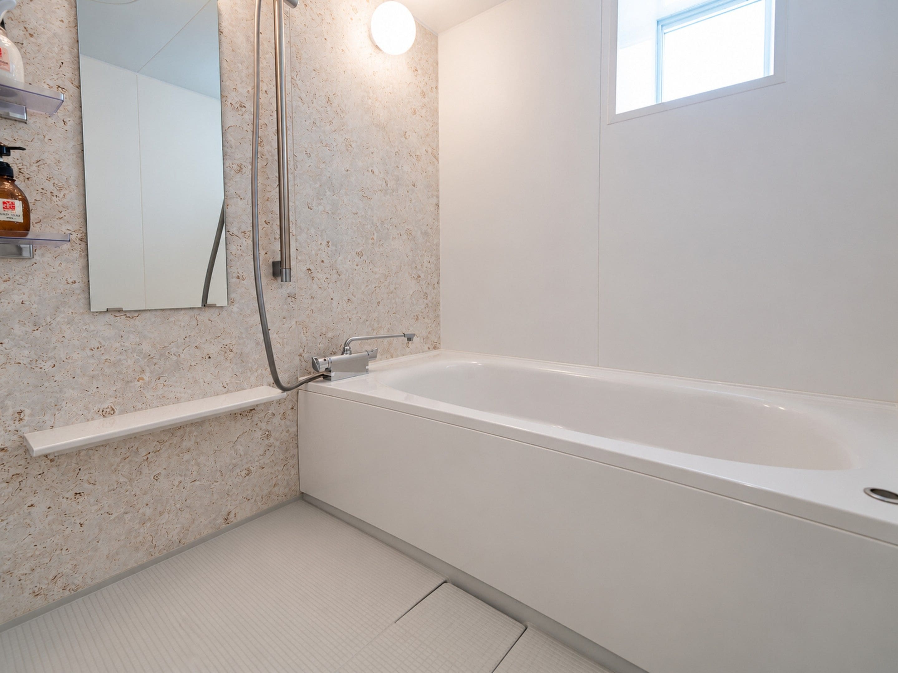 Un baño con bañera, ducha, espejo y ventana.