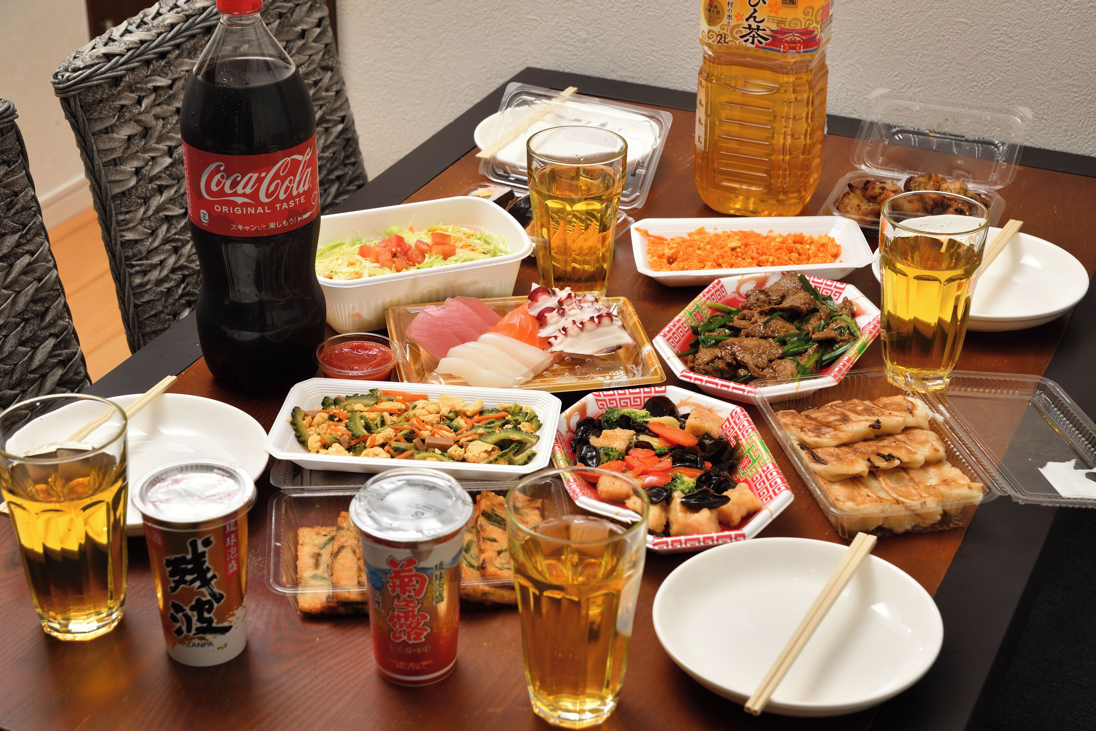 A table set with various dishes, drinks, and a Coca-Cola bottle.