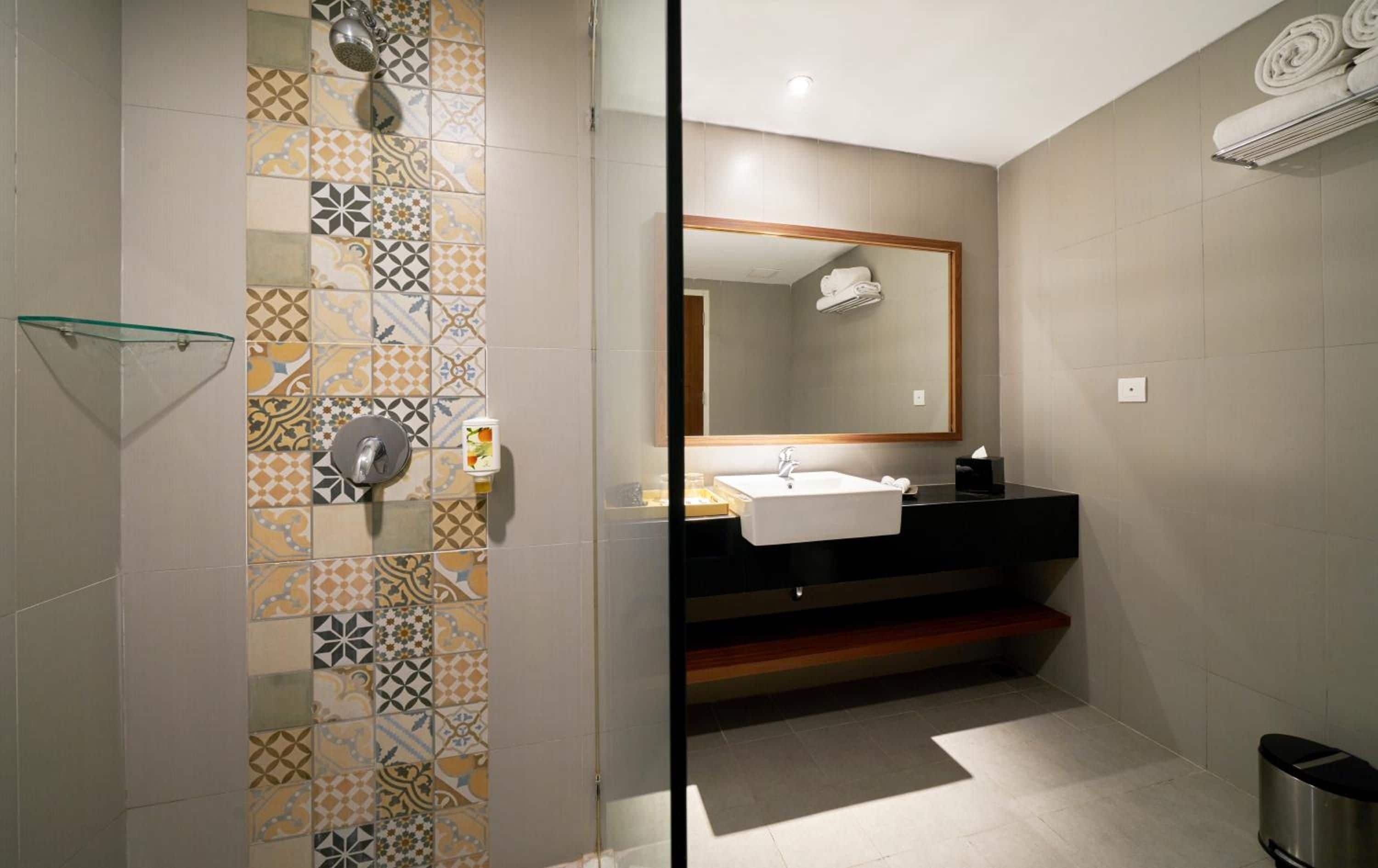 A modern bathroom with a shower, a sink, and a mirror.