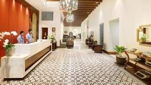 A hotel lobby with a reception desk, a patterned floor, and a modern chandelier. - Kokoon Hotel Surabaya (Surabaya)