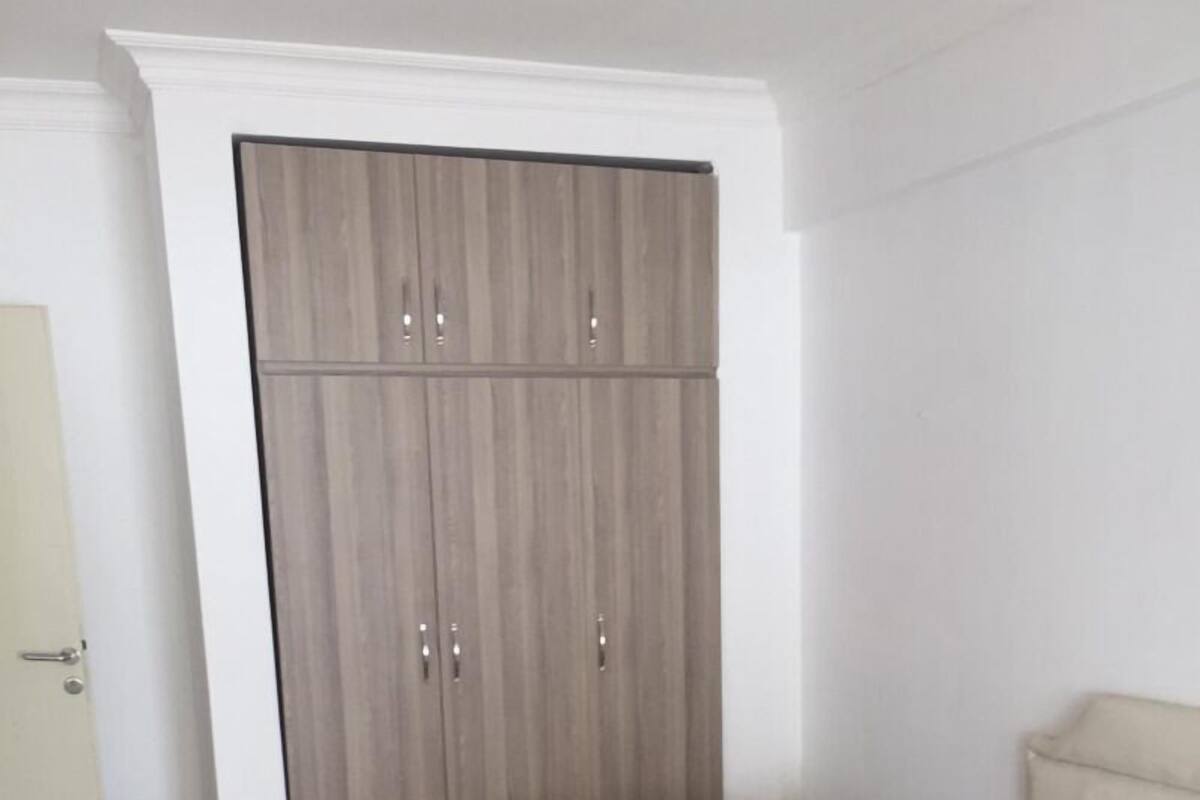 A bedroom with a wardrobe, two mattresses, and a bed.