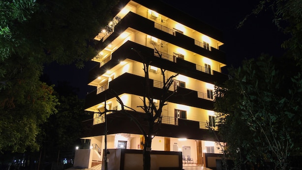 A multi-story building with balconies and a staircase leading to the entrance. - Itsy Hotels Riyas Grand (Tirupati)
