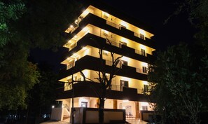 Un edificio de varios pisos con balcones y una escalera que lleva a la entrada.