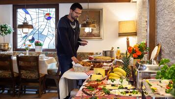 Ein Buffet mit einer Auswahl an Speisen, darunter Obst, Käse und Fleisch.