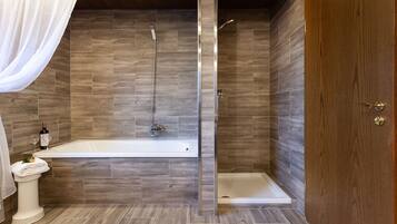 A modern bathroom with a bathtub, shower, and toilet.