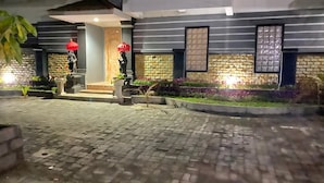 A building with a stone facade, a brick pathway, and potted plants. - Arta Garden Guest House & Hostel (Ubud)
