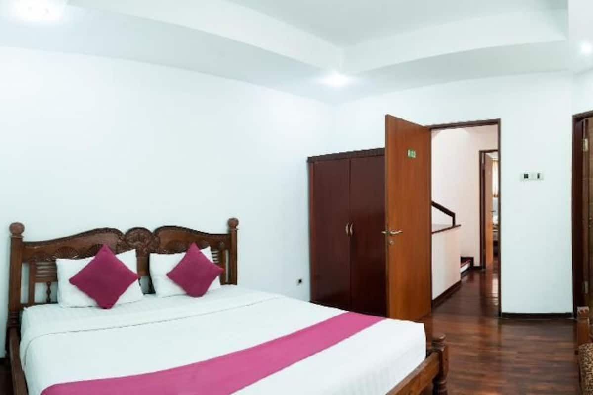 Une chambre d’hôtel comprenant un lit, une armoire et un petit coin salon.