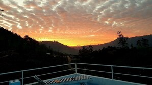 Vista al atardecer desde un balcón con piscina.