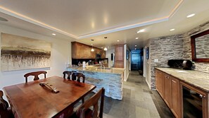A modern kitchen with a stone island, wooden cabinets, and pendant lighting. - Spacious 2 BR Units at 1849 Condos with FREE Pool, Parking & Wifi (Mammoth Lakes)