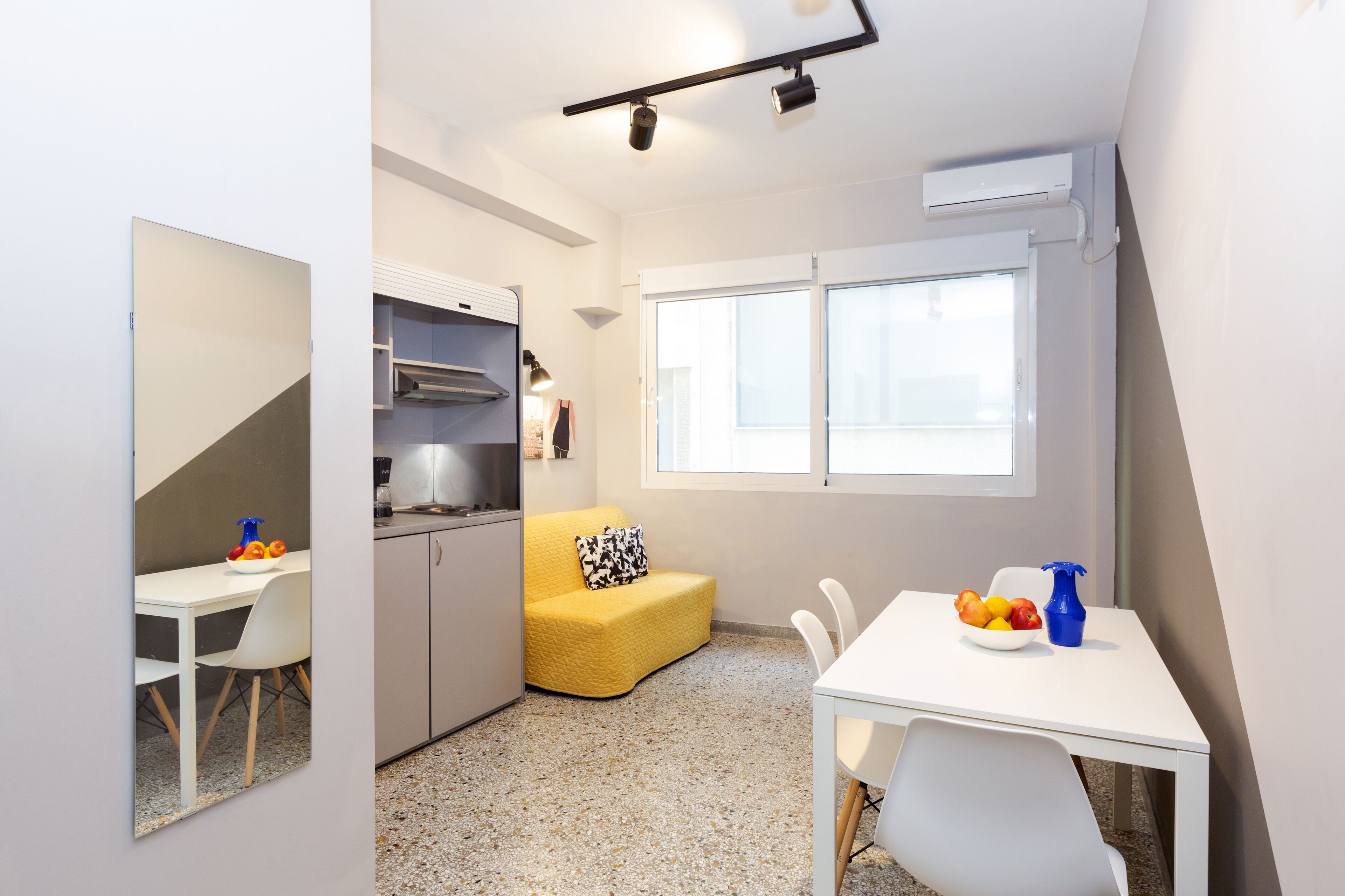 Cocina compacta con comedor, kitchenette y ventana que proporciona luz natural.
