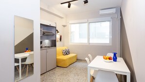 Een kleine keuken met een eethoek, een kitchenette en een raam dat voor natuurlijk licht zorgt.