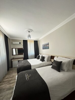 A hotel room with two beds, a desk, and a small kitchenette. - Cetinler Hotel (Demirköy)